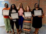 group of people holding framed certificates